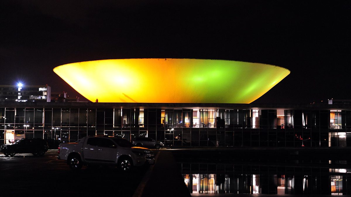 Cúpula do Congresso Nacional iluminada de verde e amarelo, em Brasília