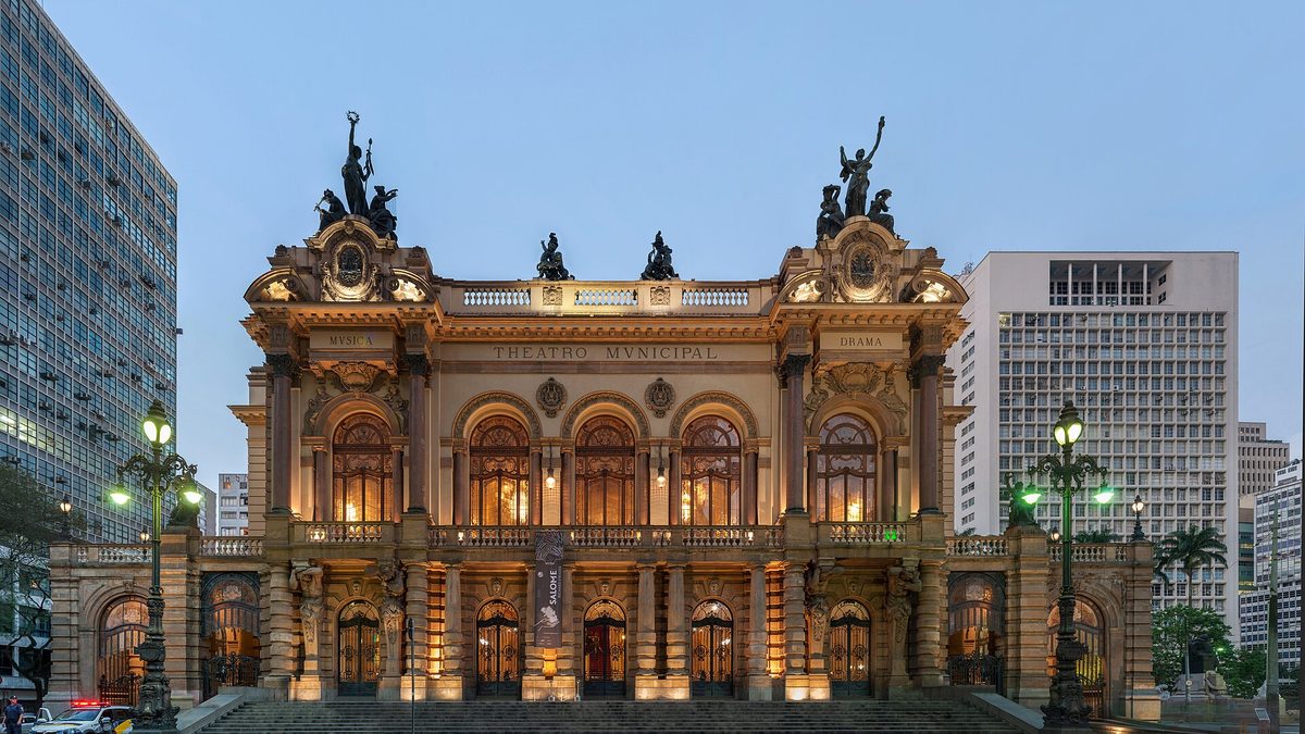 Fachada iluminada do Theatro Municipal de São Paulo ao entardecer