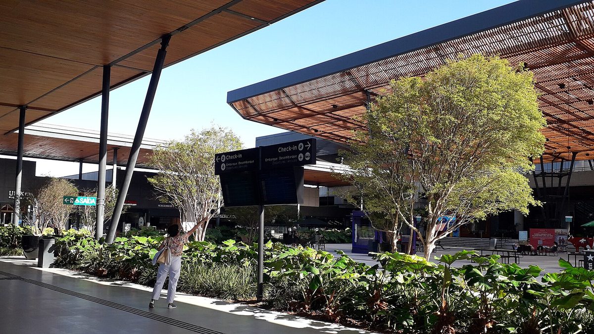 Área externa do terminal do aeroporto de Florianópolis, com jardim e cobertura
